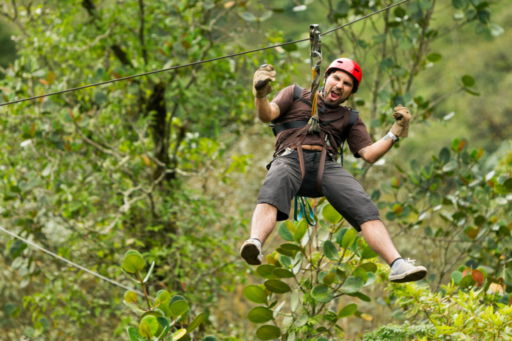 Man experiencing the thrill of a tree top adventure