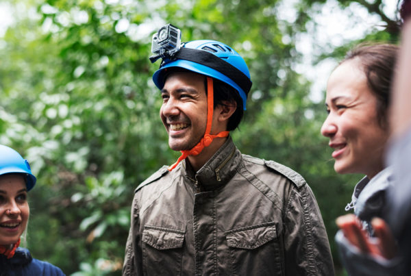 Man smiling while wearing a zip lining helmet