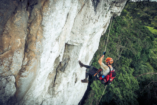 Rock climber rappelling down a cliff