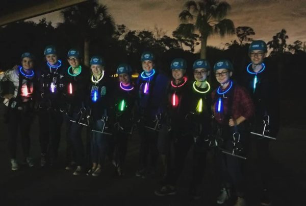 Group with glowsticks around their necks preparing for a moonlight canopy tour at Empower Adventures in Tampa Bay Florida
