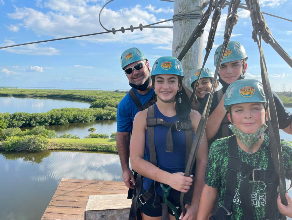 Family with kids on a zip line platform