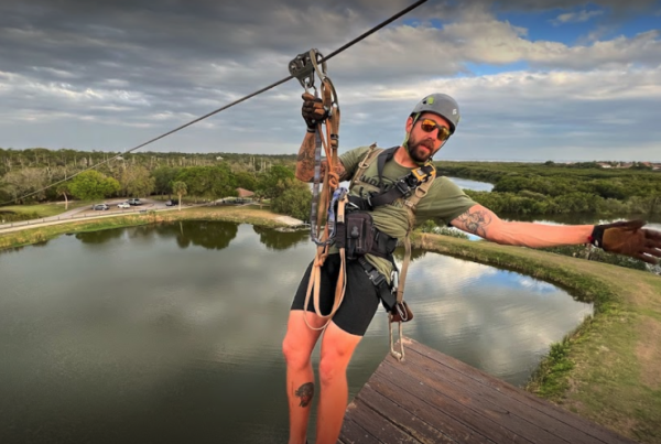 A man celebrates while zip lining in the heat.